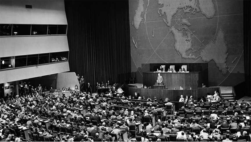 A wide view of the United Nations General Assembly in session in 1947, with delegates seated before a large world map.
